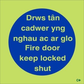 Glow in the dark Fire Door Keep Locked Shut sign in Welsh and English