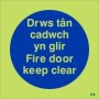 Glow in the dark Fire Door Keep Clear sign in Welsh and English