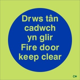 Glow in the dark Fire Door Keep Clear sign in Welsh and English