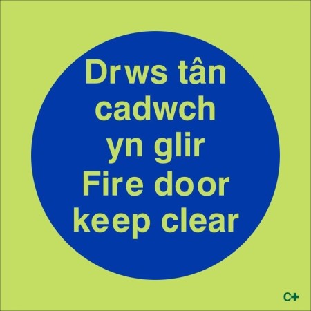 Glow in the dark Fire Door Keep Clear sign in Welsh and English