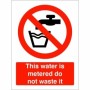 Red and white This Water Is Metered Do Not Waste It Sign with tap symbol