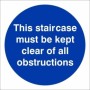 This Staircase Must Be Kept Clear Of All Obstructions mandatory sign with white text on a blue circular background