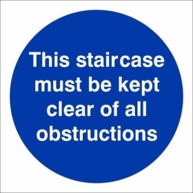 This Staircase Must Be Kept Clear Of All Obstructions mandatory sign with white text on a blue circular background