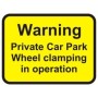 Warning private car park wheel clamping in operation sign with bold black text on yellow background